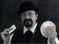 male magician holding fanned deck of cards