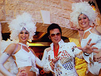 Elvis impersonator with two female showgirls