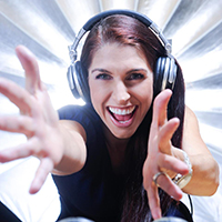female DJ in earphones with hands reaching forward